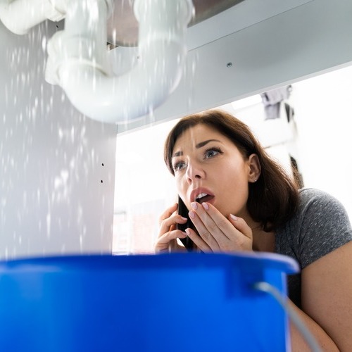 woman calling a plumber for leaking pipes