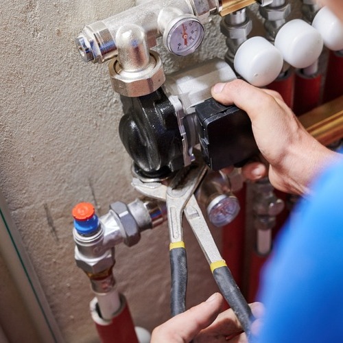 close-up of a worker installing a plumbing pump