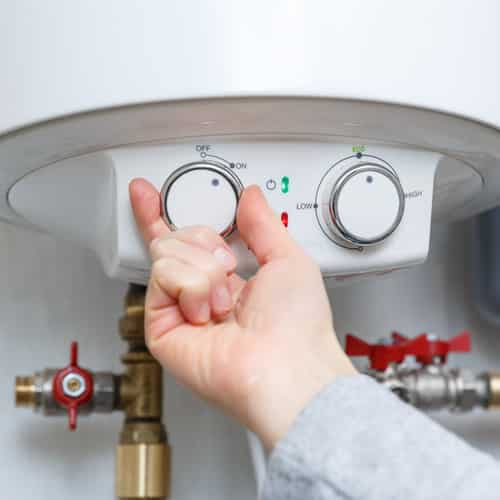 hand turning on a hot water heater