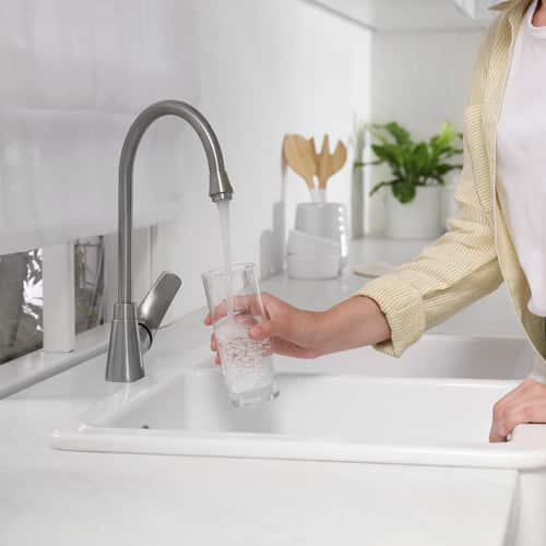 woman filling a glass of water