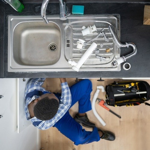 view from above of a plumber fixing a sink