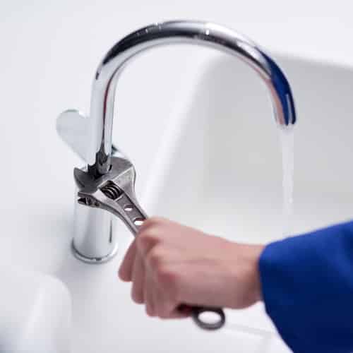 close-up of a plumber fixing a faucet