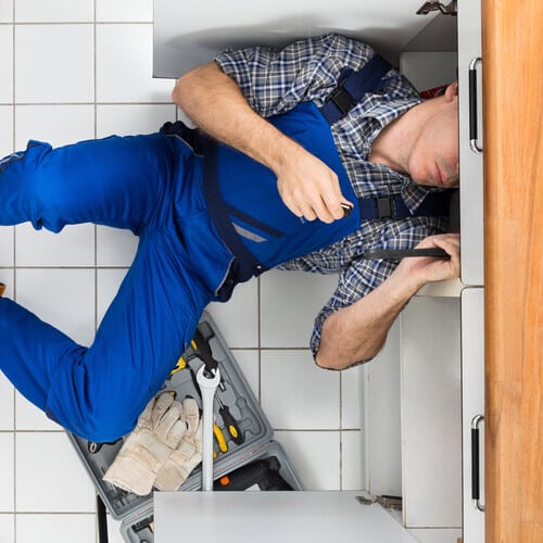 view from above of a plumber repairing a sink
