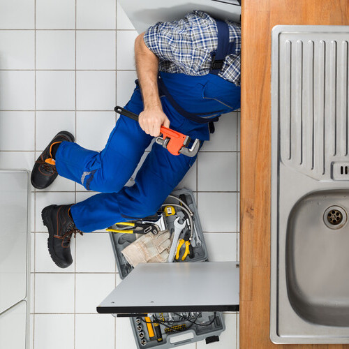 view from above of a plumber repairing a sink