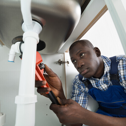 close-up of a plumber fixing a pipe