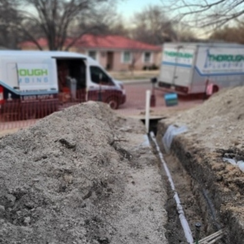 a plumbing van behind a water pipe in the ground